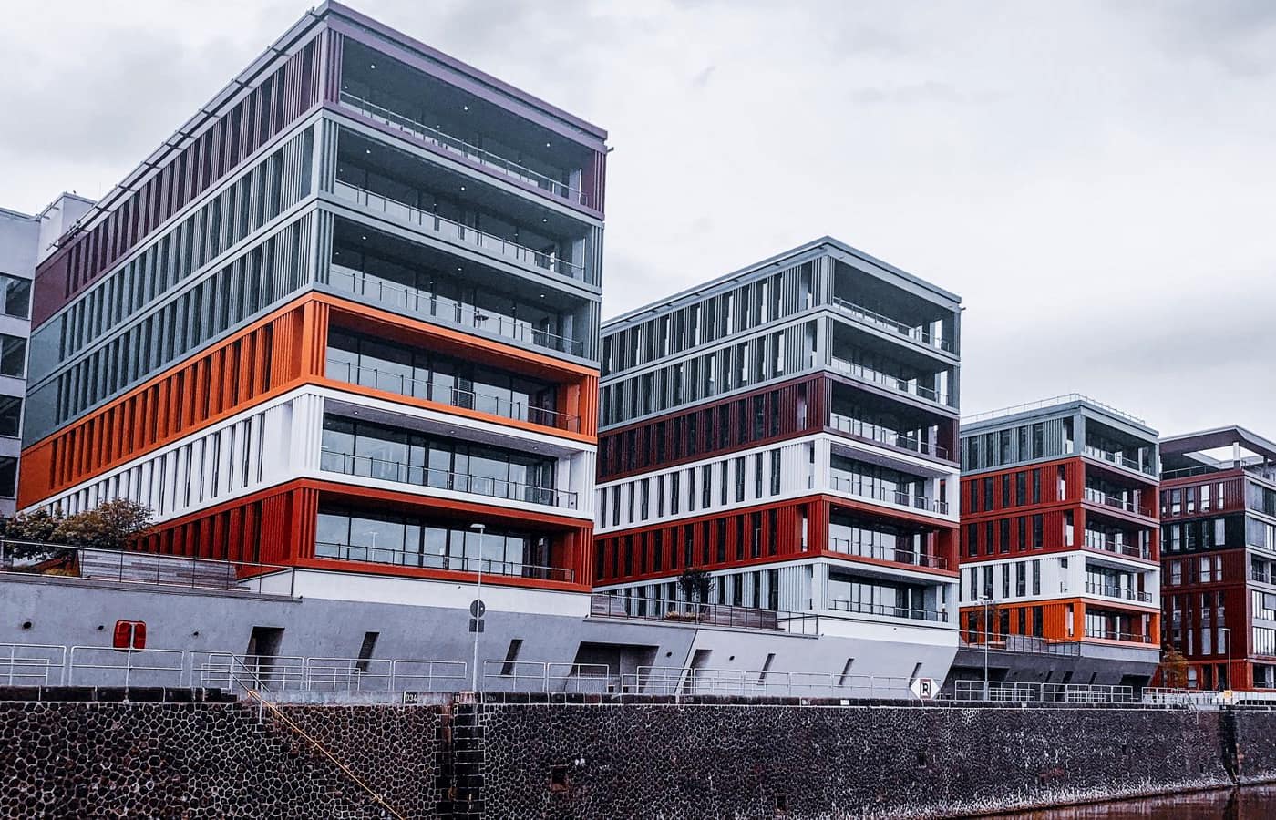 A modern mixed-use building complex with staggered floors and balconies.